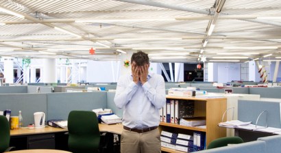 Man with hands on head in middle of office