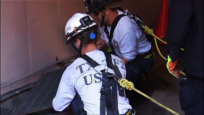 A man fell through a grate in Downtown Dallas and was trapped below a parking garage entrance until rescue crews could pull him out.
