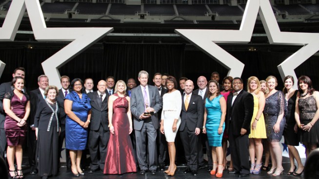 NBC 5 President/General Manager Tom Ehlmann (center in purple tie) holds the Station Excellence Emmy at the 2012 Lone Star Emmy Gala at Cowboys Stadium along with several NBC 5 KXAS-TV staffers.