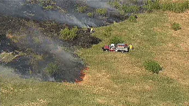 Crews have gained control of a grass fire at DFW Airport that shut down two runways.
