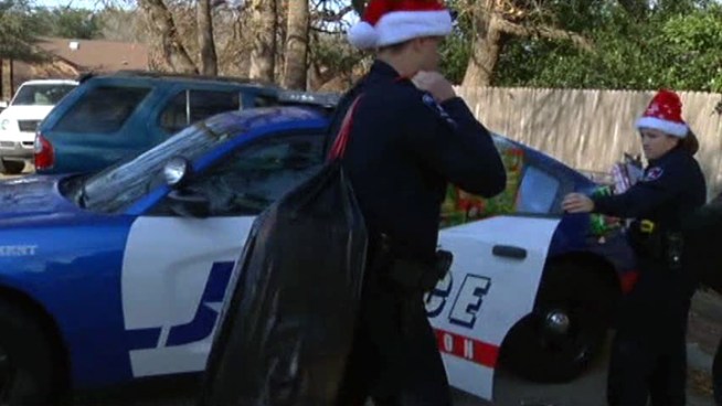 Arlington police officers deliver gifts to 12 families on Christmas Eve.