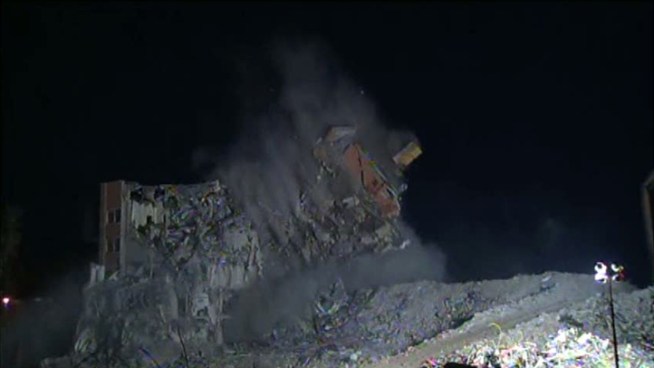 The final wall of a 12-story building at the vacant St. Joseph Hospital complex came down Tuesday night.