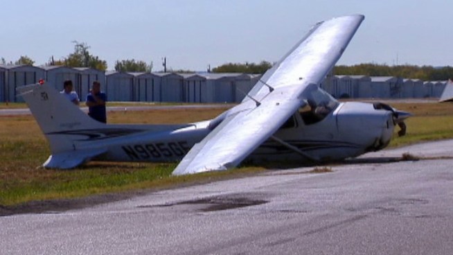 At least two people are injured when a plane hits a car on the runway and comes to a stop in a field.
