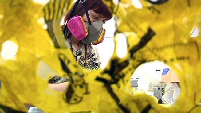 A gas mask, one hot iron and plastic bags are all this artist needs to get to work.