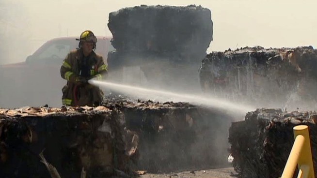 Two Dallas firefighters went to a hospital for heat-related issues while battling a large fire at a recycling center.