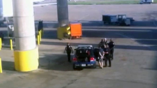 An airline passenger who was escorted off a US Airways flight after someone called in a phony bomb threat was later arrested in North Texas on unrelated outstanding warrants.