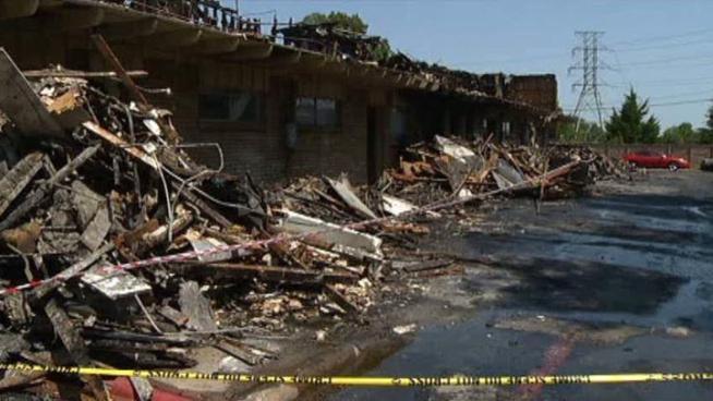 Neighbors help residents go through what is left of their homes after a deadly fire swept through an Arlington apartment building, killing two people.
