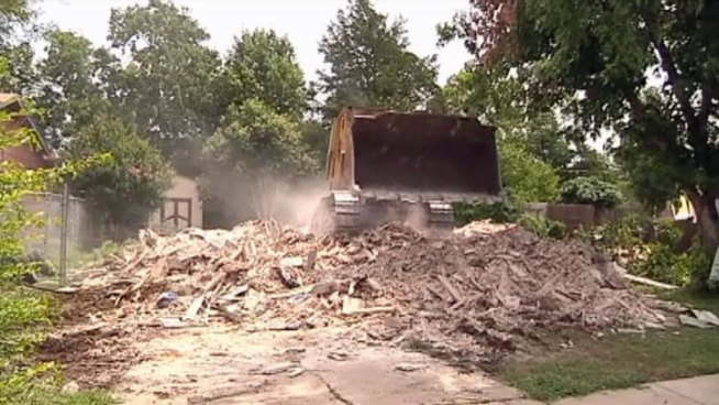 Diane and Jesse Wilmore's home was destroyed by two trailers tossed during April's twister in Dallas. Friday what was left of their home was torn down to make way for new construction.