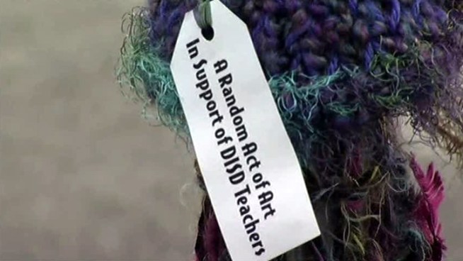 A group of knitters is decorating public fixtures with colorful yarn displays.