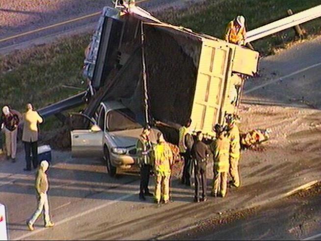 Video from Chopper 5 showed a dump truck loaded with dirt on it's side resting on top of a car on I-35W northbound, near Meacham Boulevard.
