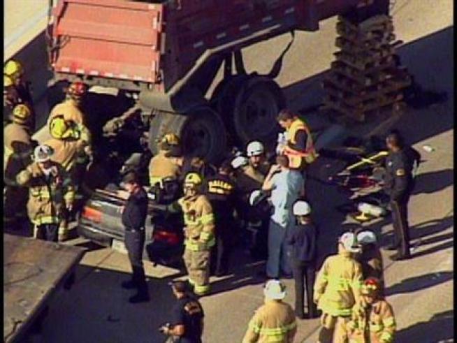 At least two people are injured after a rock hauler rolls over and crushes a car on Interstate 35E in <a title=