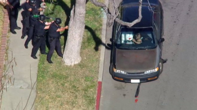 Aerial video shows a man repeatedly filling balloons and then inhaling their contents while police surround the vehicle. This clip was first aired live on NBCLA.com on Feb. 1, 2013. It has been edited for time.