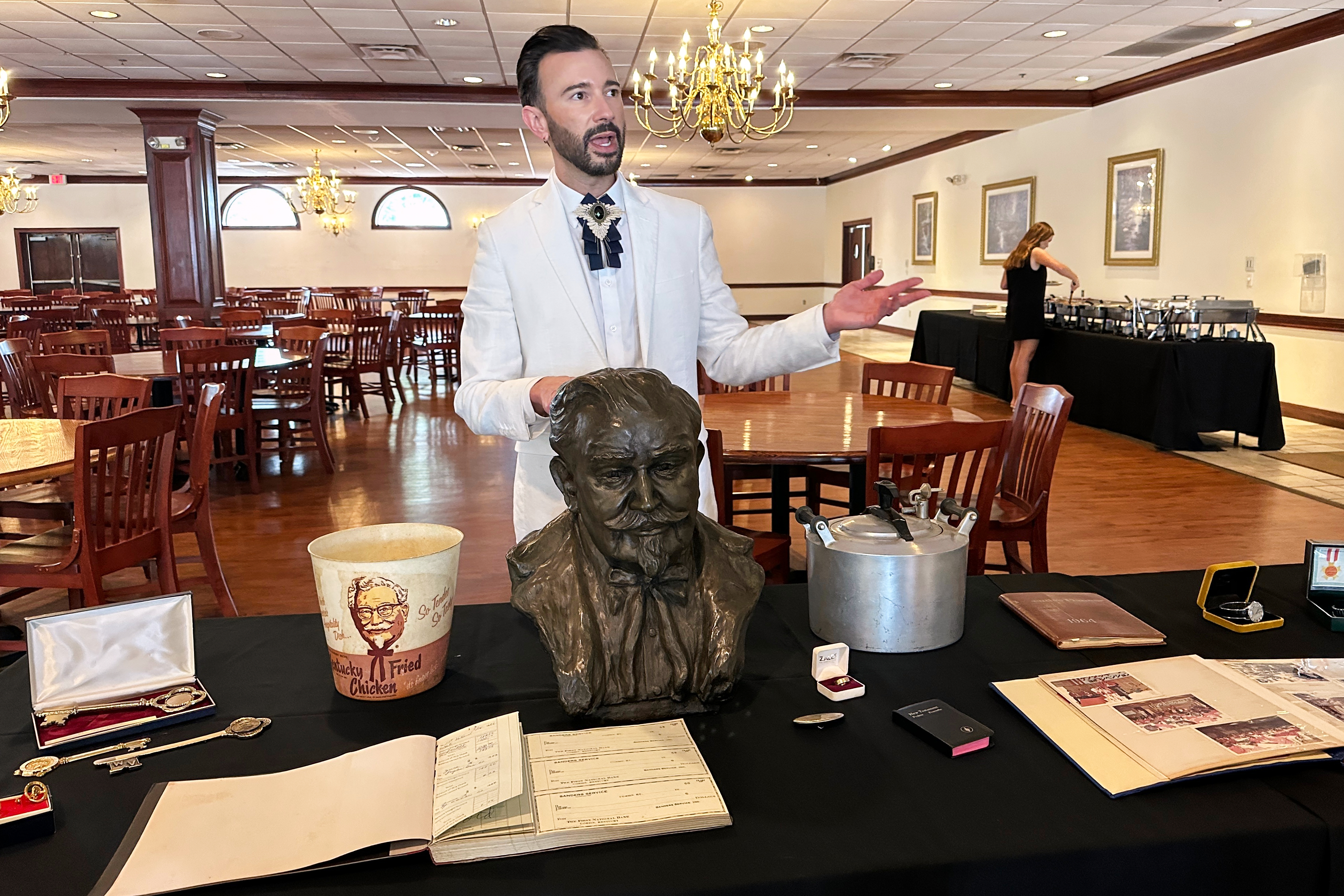 Auctioneer Jonathan Klunk gestures to a display of personal items