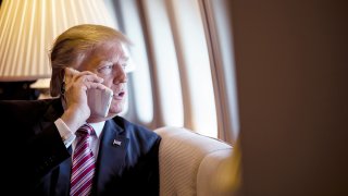 President Donald Trump talks on the phone aboard Air Force One d