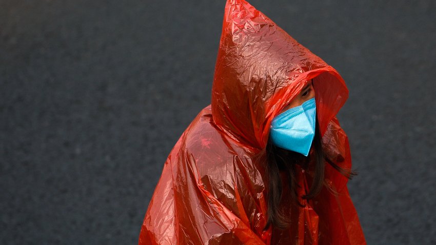 A masked woman in a plastic rain coat walks on a street in Beijing, Tuesday, Feb. 11, 2020. China’s daily death toll from a new virus topped 100 for the first time and pushed the total past 1,000 dead, authorities said Tuesday after leader Xi Jinping visited a health center to rally public morale amid little sign the contagion is abating.