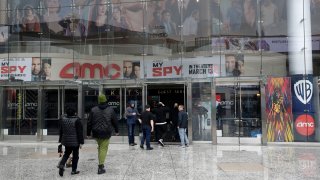 People enter an AMC theater in Los Angeles.