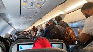 FILE - In this Monday, April 27, 2020, file photo, provided by Vince Warburton, passengers get off an American Airlines flight after they landed at Los Angeles International Airport in Los Angeles.