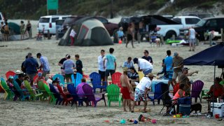 People gather on the beach for the Memorial Day weekend in Port Aransas, Texas, Saturday, May 23, 2020. Beachgoers are being urged to practice social distancing to guard against COVID-19. (AP Photo/Eric Gay)