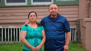 In this photo provided by Cristobal Francisquez, his parents Paulina and Marcos Francisco pose for a photo in front of their house in Sioux City, Iowa, Monday, May 25, 2020. They bought the home after years of working in a meatpacking plant and other food processing jobs.