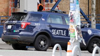 Workers put up plywood over the windows of a Seattle police precinct Monday, June 8, 2020, in Seattle
