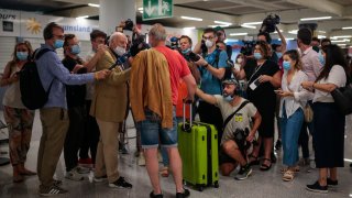 A TUI X3 2312 Duesseldorf-Mallorca flight passenger talks to the press at Son Sant Joan airport in Palma de Mallorca, Spain, Monday, June 15, 2020. Borders opened up across Europe on Monday after three months of coronavirus closures that began chaotically in March. But many restrictions persist, it's unclear how keen Europeans will be to travel this summer and the continent is still closed to Americans, Asians and other international tourists.