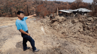 Justin Kam surveys his destroyed home at Balmoral, Australia, Tuesday, Jan. 7, 2020.