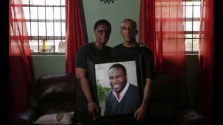 In this Sept. 25, 2018 file photo, Allison and Bertrum Jean pose as they hold a portrait of their late son, Botham Shem Jean.