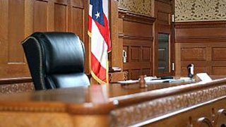 the judge's stand inside a courtroom with a US flag in the background