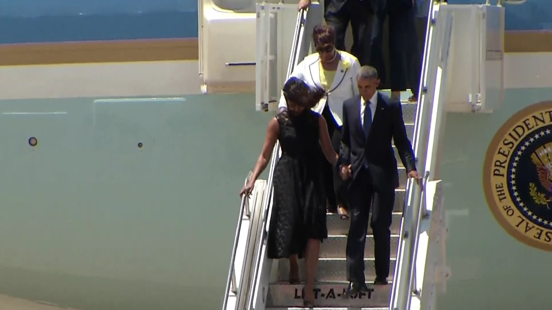 President Barack Obama and wife Michelle exit Air Force One and make their way to the Interfaith Memorial service.