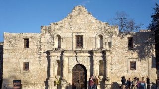 Tourists pose for a souvenir photograph in front of Mission San Antonio de Valero, better known as The Alamo. The former Franciscan mission was the site of the Battle of the Alamo in 1836 during Texas' war for independence from Mexico where Texian defenders were defeated by Mexican troops under General Antonio Lopez de Santa Anna.