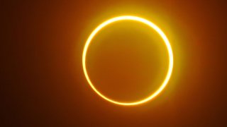 The moon moves in front of the sun in a rare "ring of fire" solar eclipse