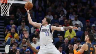 The Dallas Mavericks' Luka Doncic (77) scores easily in front of the Orlando Magic's Nikola Vucevic, right, at the Amway Center in Orlando, Fla., on Friday, Feb. 21, 2020.