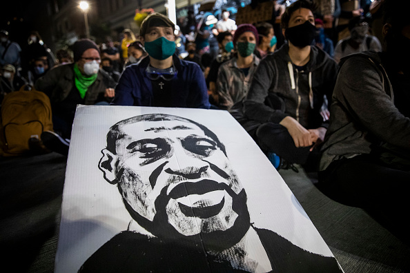 Demonstrators attend a "Sit Out the Curfew" protest against the death of George Floyd, who died May 25 in Minneapolis while in police custody, along a street in Oakland, California on June 3, 2020.