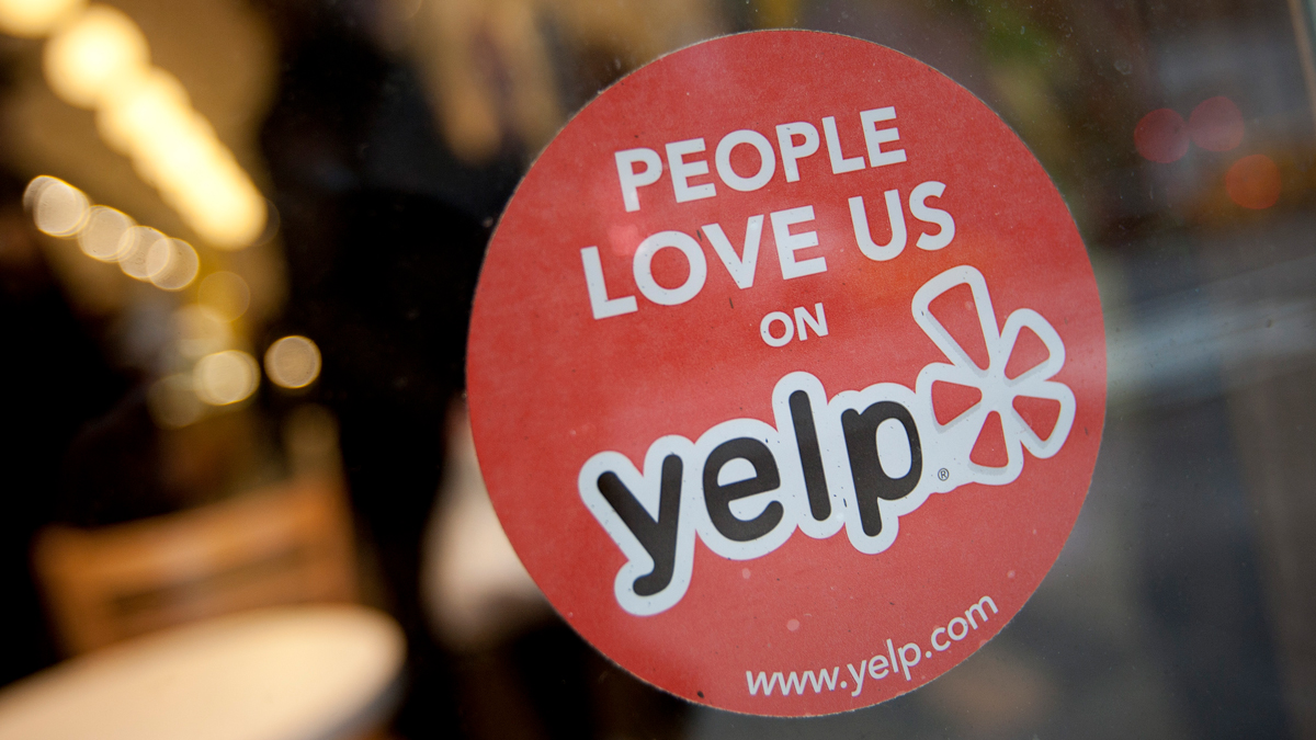 In this March 1, 2012, file photo, the Yelp Inc. logo is displayed in the window of a restaurant in New York.