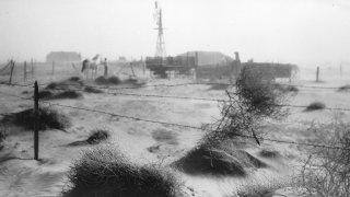 A dust bowl farmstead in Dallam County, Texas, showing the desolation produced by the dust and wind on the countryside.