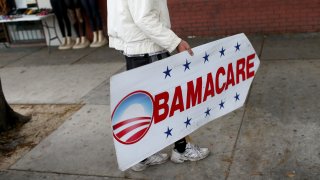 Pedro Rojas holds a sign directing people to an insurance company where they can sign up for the Affordable Care Act, also known as Obamacare, on Feb. 5, 2015, in Miami, Florida.