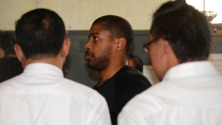 Vontrey Clark (C), a former US policeman, is escorted by Indonesian police from a holding cell in Denpasar to Ngurah Rai international airport as he is deported from the resort island of Bali on September 2, 2015.
