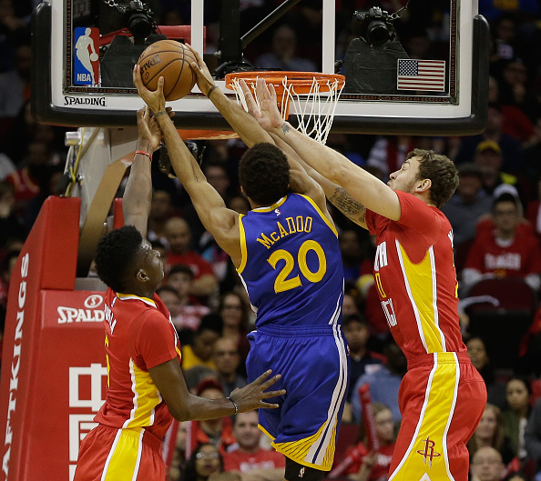 HOUSTON, TX - DECEMBER 31: James Michael McAdoo #20 of the Golden State Warriors drives to the basket between Clint Capela #15 of the Houston Rockets and Donatas Motiejunas #20 in the second quarter at Toyota Center on December 31, 2015 in Houston, Texas. NOTE TO USER: User expressly acknowledges and agrees that, by downloading and or using this Photograph, User is consenting to the terms and conditions of the Getty Images License Agreement. Mandatory Copyright Notice: Copyright 2015 NBAE (Photo by Bob Levey/Getty Images)