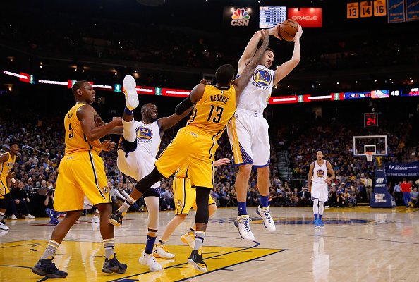 OAKLAND, CA - JANUARY 22: Klay Thompson #11 of the Golden State Warriors and Paul George #13 of the Indiana Pacers go for a rebound as Draymond Green #23 of the Golden State Warriors and Lavoy Allen #5 of the Indiana Pacers get tangled up at ORACLE Arena on January 22, 2016 in Oakland, California. NOTE TO USER: User expressly acknowledges and agrees that, by downloading and or using this photograph, User is consenting to the terms and conditions of the Getty Images License Agreement. (Photo by Ezra Shaw/Getty Images)