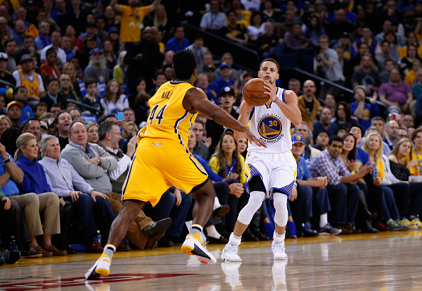 OAKLAND, CA - JANUARY 22: Stephen Curry #30 of the Golden State Warriors shoots a half-court over Solomon Hill #44 of the Indiana Pacers to end the first half of their game at ORACLE Arena on January 22, 2016 in Oakland, California. NOTE TO USER: User expressly acknowledges and agrees that, by downloading and or using this photograph, User is consenting to the terms and conditions of the Getty Images License Agreement. (Photo by Ezra Shaw/Getty Images)