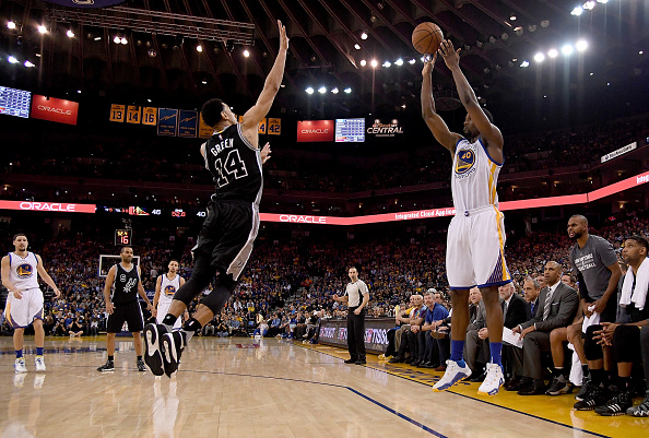 OAKLAND, CALIFORNIA - APRIL 07: Harrison Barnes #40 of the Golden State Warriors shoots and makes a three-point basket over Danny Green #14 of the San Antonio Spurs in the second quarter of an NBA Basketball game at ORACLE Arena on April 7, 2016 in Oakland, California. NOTE TO USER: User expressly acknowledges and agrees that, by downloading and or using this photograph, User is consenting to the terms and conditions of the Getty Images License Agreement. (Photo by Thearon W. Henderson/Getty Images)