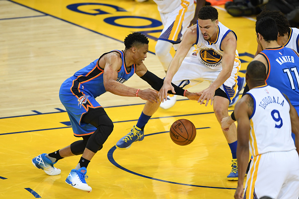 OAKLAND, CA - MAY 26: Russell Westbrook #0 of the Oklahoma City Thunder reaches for a loose ball against Klay Thompson #11 of the Golden State Warriors during Game Five of the Western Conference Finals during the 2016 NBA Playoffs at ORACLE Arena on May 26, 2016 in Oakland, California. (Photo by Thearon W. Henderson/Getty Images)