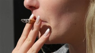 young woman smokes a cigarette