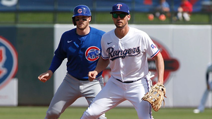 Ian Happ #8 of the Chicago Cubs takes a lead off first base behind Greg Bird #20 of the Texas Rangers during the first inning of a Cactus League spring training game at Surprise Stadium on Feb. 27, 2020 in Surprise, Arizona.
