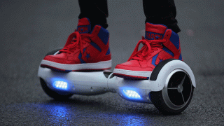 In this Oct. 13, 2015, file photo, a youth poses as he rides a hoverboard.