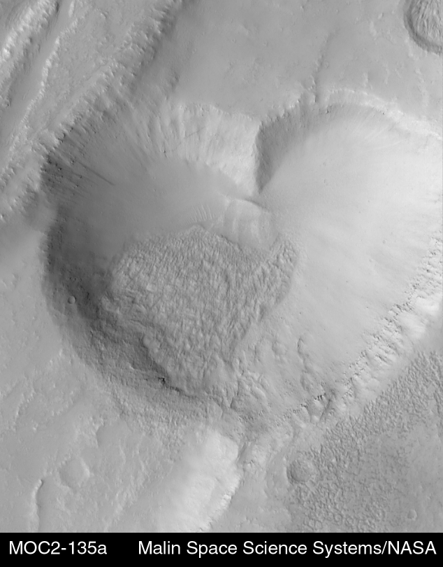 EMPTY_CAPTION"The heart-shaped pit is about 2.3 kilometers (1.4 miles) at its widest. The image was targeted by the MOC team in order to examine the relationship between a lava flow (margins indicated by white arrows, above right) and the graben and pits that disrupted and cut across the flow. The graben, pit, and lava flow are located on the east flank of the Alba Patera volcano in northern Tharsis." Released in 1999.