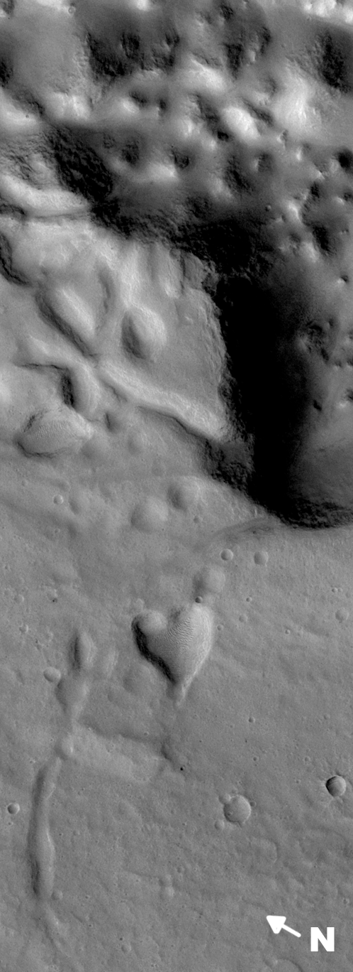 EMPTY_CAPTION"This picture of a heart-shaped pit was taken on 26 February 2008 by the CTX camera aboard MRO. It is approximately 2 km long and is centered at 3.7° N, 29.9° W. The pit is one of many adjacent to Hydaspis Chaos, a jumbled topographic depression thought to have formed by collapse of the surface due to—perhaps—catastrophic release of groundwater." Released in 2009.