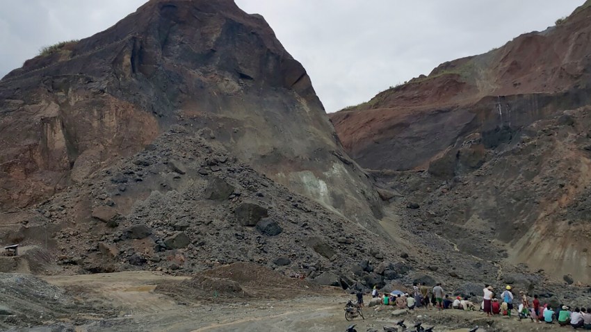 In this photograph taken on May 24, 2016, rescue workers gather beside a landslide in a jade mining area on the outskirts of Hpakant in Myanmar's northern Kachin State.