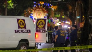 Emergency personnel stand where a pedestrian was hit and killed by a float