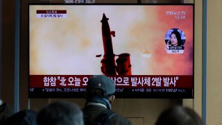 In this file photo, people watch a TV screen showing a news program reporting about North Korea's firing of projectiles with a file image at the Seoul Railway Station in Seoul, South Korea, Monday, March 2, 2020.